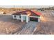 A modern stucco home boasts a red tile roof and attached garage, surrounded by a natural desert landscape at 21165 W Carver Rd, Buckeye, AZ 85326