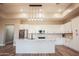 Bright modern kitchen features stainless steel appliances, white cabinets, marble countertops, and a large island at 21165 W Carver Rd, Buckeye, AZ 85326