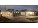 Night view of a remodeled home with a well-lit front yard and attached garage at 2329 E Turney Ave, Phoenix, AZ 85016