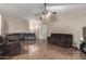 Living room with dark brown leather sectional and tile flooring at 2535 N 87Th Ave, Phoenix, AZ 85037