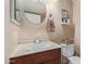 Small bathroom with a round mirror and wood vanity at 8934 W Ocotillo Rd, Glendale, AZ 85305