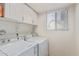 Bright laundry room with washer, dryer, and cabinets at 8934 W Ocotillo Rd, Glendale, AZ 85305