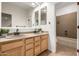 Well-lit bathroom featuring a double sink vanity, tile flooring, and a shower-over-tub, providing a functional space at 14539 W Sheridan St, Goodyear, AZ 85395
