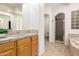 Well-lit bathroom features a walk-in shower, sink with wood cabinets, and modern fixtures at 14539 W Sheridan St, Goodyear, AZ 85395