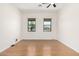 An empty bedroom with hardwood floors, ceiling fan and large windows at 14539 W Sheridan St, Goodyear, AZ 85395