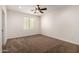 Neutral-toned bedroom featuring plush carpeting and a ceiling fan for added comfort at 14539 W Sheridan St, Goodyear, AZ 85395