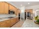 Well-lit kitchen features granite countertops, stainless steel appliances, and ample wood cabinetry at 14539 W Sheridan St, Goodyear, AZ 85395