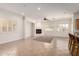 Spacious living room with tiled floors, fireplace, ceiling fan, and bright windows at 14539 W Sheridan St, Goodyear, AZ 85395