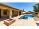 Resort-style backyard showcasing a sparkling pool, spa, covered patio, and cozy fire pit at 14539 W Sheridan St, Goodyear, AZ 85395