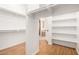 A bright walk-in closet features wood floors, and customizable shelving for clothing and storage at 14539 W Sheridan St, Goodyear, AZ 85395