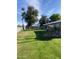 Spacious backyard with grassy lawn, mature trees, and a building in the background at 2687 W Ocotillo Rd, Phoenix, AZ 85017