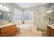 Bathroom featuring a soaking tub, glass-enclosed shower, and dual vanities at 27600 N 130Th Ave, Peoria, AZ 85383