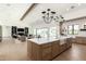 The kitchen features a large island with marble countertop, farmhouse sink, wood cabinets, and designer chandeliers at 6040 E Lafayette Blvd, Scottsdale, AZ 85251