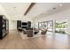 Bright living room featuring a beamed ceiling, light wood floors, and sliding glass doors with views of the pool at 6040 E Lafayette Blvd, Scottsdale, AZ 85251