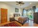 Spacious bedroom with wood flooring, a ceiling fan, and access to a private patio at 6074 E Los Reales Dr, Carefree, AZ 85377