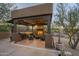 Covered outdoor kitchen with a fireplace and seating area at 6074 E Los Reales Dr, Carefree, AZ 85377