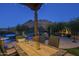 Outdoor dining area with mountain views at night at 6074 E Los Reales Dr, Carefree, AZ 85377