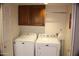 Laundry room with washer, dryer, and wood cabinets at 9217 N 106Th Way, Scottsdale, AZ 85258