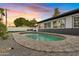 Inviting oval pool with surrounding stone patio and fire pit at 1302 W Golden Ln, Phoenix, AZ 85021