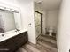 Bathroom featuring double vanity, framed mirror, tiled walk-in shower, and neutral walls at 15221 N Clubgate Dr # 1110, Scottsdale, AZ 85254