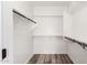 Spacious closet featuring wood floors, white walls, and shelving with hanging rods at 15221 N Clubgate Dr # 1110, Scottsdale, AZ 85254