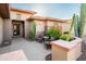 Front entry with seating area, mature plants, and decorative stone at 19425 N Guardian Ln, Surprise, AZ 85387