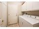 Bright laundry room, washer, dryer, and cabinets at 19425 N Guardian Ln, Surprise, AZ 85387