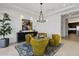 Contemporary dining area with stylish yellow chairs, a modern chandelier, and an artistic wall hanging at 19702 E Melissa Pl, Queen Creek, AZ 85142