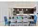 A modern open kitchen with an extended island, a dining table and stylish pendant lighting at 19702 E Melissa Pl, Queen Creek, AZ 85142