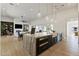 Modern kitchen island with seating and dark cabinetry, connecting to the living room at 19702 E Melissa Pl, Queen Creek, AZ 85142