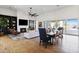 Open-concept living area with a fireplace, modern fan, a long dining table, and sliding doors to the backyard at 19702 E Melissa Pl, Queen Creek, AZ 85142