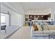 Bright, open living space with a large sliding glass door, hardwood floors, and a view into the modern kitchen at 19702 E Melissa Pl, Queen Creek, AZ 85142