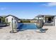 Inviting backyard oasis featuring a pool, spa, and cabana with stylish hanging chairs, perfect for relaxation and entertaining at 19702 E Melissa Pl, Queen Creek, AZ 85142