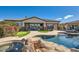 Back exterior of home with covered patio, stone accents and pool access at 27432 N 66Th Way, Scottsdale, AZ 85266
