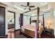 Elegant main bedroom with a four-poster bed, ensuite bathroom, and dark hardwood floors at 27432 N 66Th Way, Scottsdale, AZ 85266