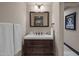 Simple bathroom with dark wood vanity and a framed mirror at 5800 E Glen Dr, Paradise Valley, AZ 85253