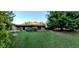 Expansive backyard featuring a lush green lawn, mature trees and a covered patio, perfect for outdoor living and entertaining at 10407 W Catalina Dr, Avondale, AZ 85392