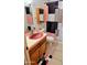 Retro bathroom featuring a pink sink and vintage wooden cabinet at 10407 W Catalina Dr, Avondale, AZ 85392
