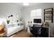 Bright home office with modern desk, shelving, and natural light from a window at 10407 W Catalina Dr, Avondale, AZ 85392