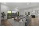Bright open-concept living room with hardwood floors, an oversized sectional, and access to a kitchen and outdoor balcony at 14828 E Valley Vista Dr, Fountain Hills, AZ 85268