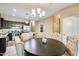 Dining area with a round table and chairs, adjacent to a modern kitchen with dark cabinets at 23800 W Pima St, Buckeye, AZ 85326