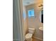 Cozy half bathroom with a pedestal sink, toilet, and window providing natural light at 280 S Evergreen Rd # 1301, Tempe, AZ 85288