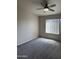 An empty bedroom with gray carpet features a window and ceiling fan with light at 280 S Evergreen Rd # 1301, Tempe, AZ 85288
