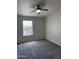 An empty bedroom with gray carpet features a window and ceiling fan with light at 280 S Evergreen Rd # 1301, Tempe, AZ 85288