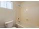 Simple bathroom with bathtub, toilet, and window at 3555 S Payton St, Mesa, AZ 85212