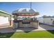 Outdoor kitchen with grill and refrigerator under a canopy at 6431 W Sierra St, Glendale, AZ 85304