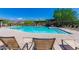 Relaxing community pool with lounge chairs and a covered patio area at 8141 E Apache Plumb Dr, Gold Canyon, AZ 85118