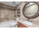 Bathroom with decorative basket storage, granite countertop and tub with tile surround at 905 E Knight Ln, Tempe, AZ 85284