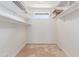Large walk-in closet with multiple shelves, neutral color palette, and small window providing natural light at 905 E Knight Ln, Tempe, AZ 85284