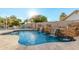 Backyard pool features decorative waterfalls, lush landscaping, and seating areas, perfect for relaxation at 905 E Knight Ln, Tempe, AZ 85284